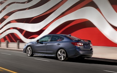 2022 Subaru Impreza Sedan driving on a road.